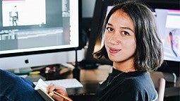 Portrait of alumna Mary Vertulfo at a desk